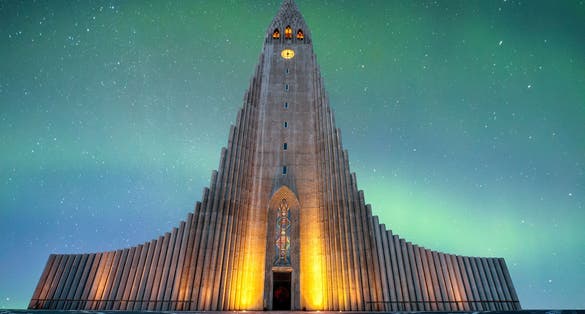 photo of hallgrímskirkja is a lutheran (Church of Iceland) church in Reykjavík It is the largest church in Iceland and the tallest structures in Iceland .There is an colorful aurora borealis in background.