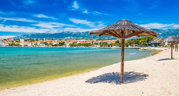 Adriatic sea shore in Croatia on Pag island, parasol on beautiful sand beach in town of Novalja