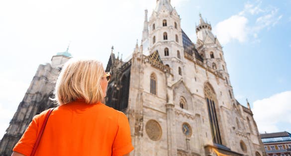 Photo of tourist stands near St. Stephen's Cathedral on Stefansplatz and enjoys the views of the main attractions of the city of Vienna, Austria.