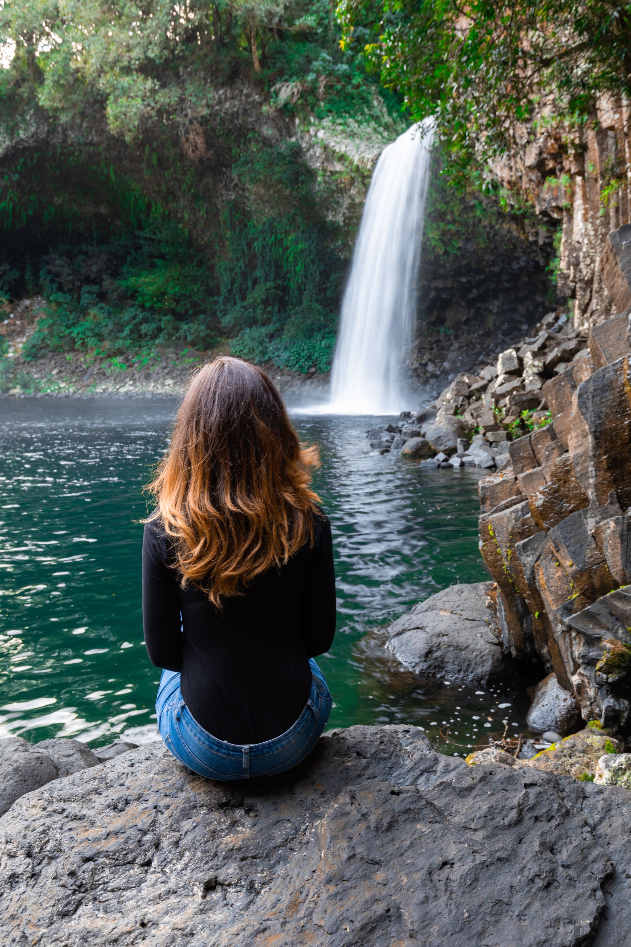 Girl watching the Bassin La Paix waterfall in Reunion Island