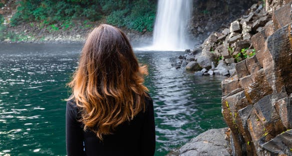 Girl watching the Bassin La Paix waterfall in Reunion Island