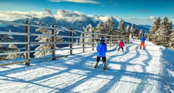 Stunning winter landscape with wonderful Bucegi mountains in background and skiers on the ski slopes,Poiana Brasov ski resort,Transylvania,Romania,Europe