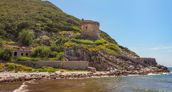 Ancient roman defense tower Torre Paola on a hill near the Mediterranean Sea in the Circeo National Park. Beautiful coast of Lungomare di Sabaudia, province of Latina, Lazio region in central Italy.
