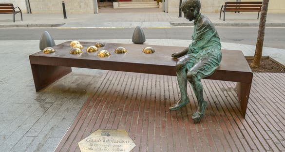 Reus, Tarragona / Spain - Street statue of the adolescent Gaudí playing marbles. Reus is the hometown of the famous Catalan architect Antoni Gaudí.