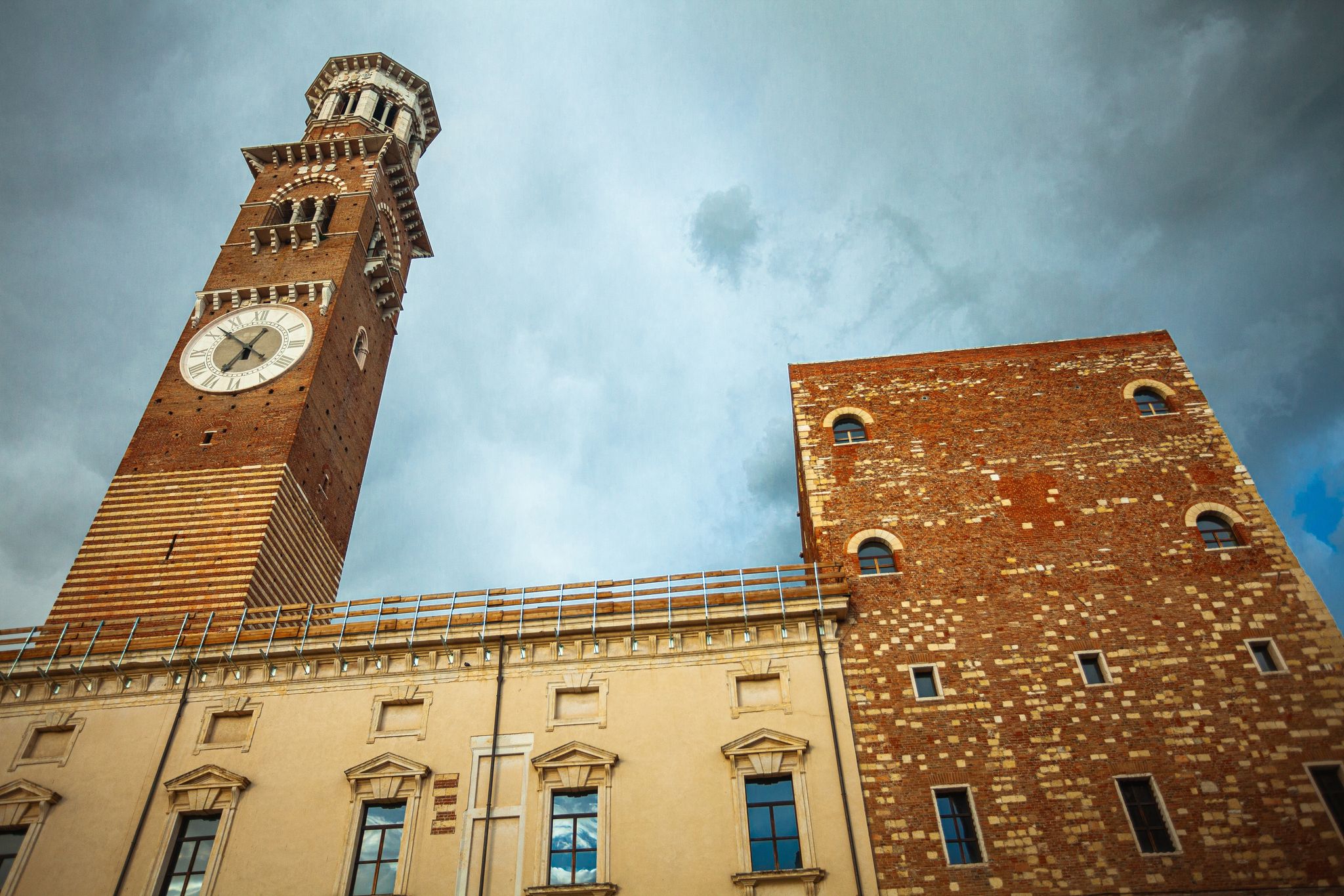 photo of Fair Verona concept. The Torre dei Lamberti - high tower in the old city centre. Dramatic cloudy sky. Outdoor shot.