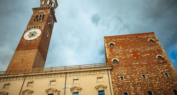 photo of Fair Verona concept. The Torre dei Lamberti - high tower in the old city centre. Dramatic cloudy sky. Outdoor shot.