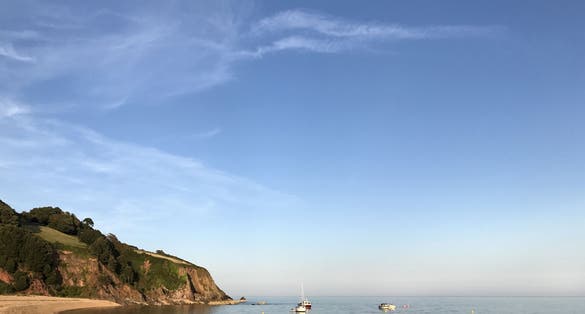 Photo of Blackpool Sands beach, Devon, United Kingdom with a calm sea and clear blue sky.