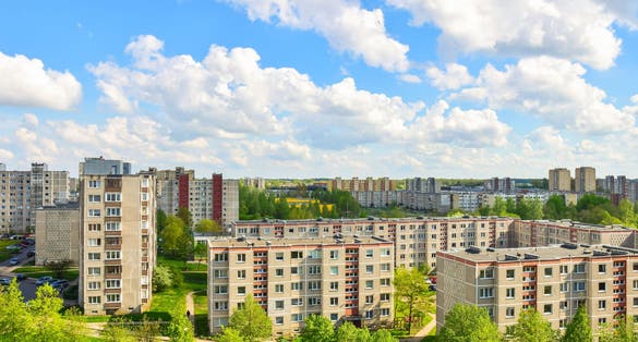 Aerial panoramic view of the southern part of Siauliai city in Lithuania.Old soviet union buildings with green nature around and yards full of cars in a sunny day.