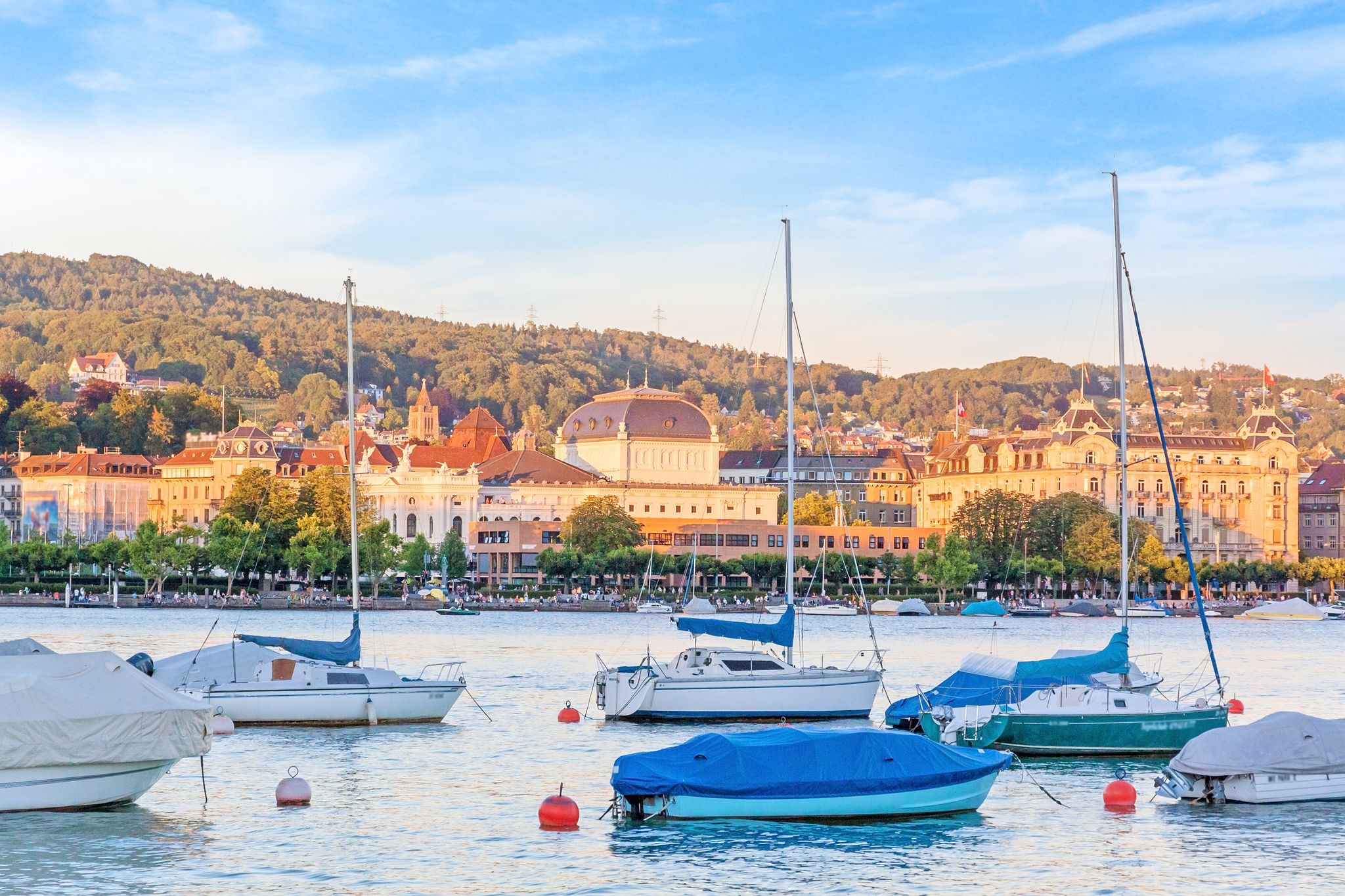 Photo of Lake Zurich with boats and Opera House in background, Switzerland.