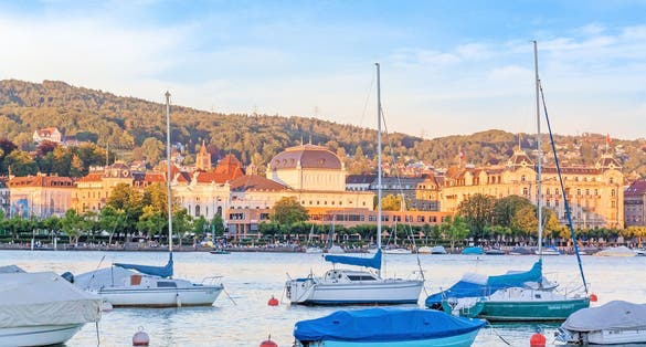 Photo of Lake Zurich with boats and Opera House in background, Switzerland.