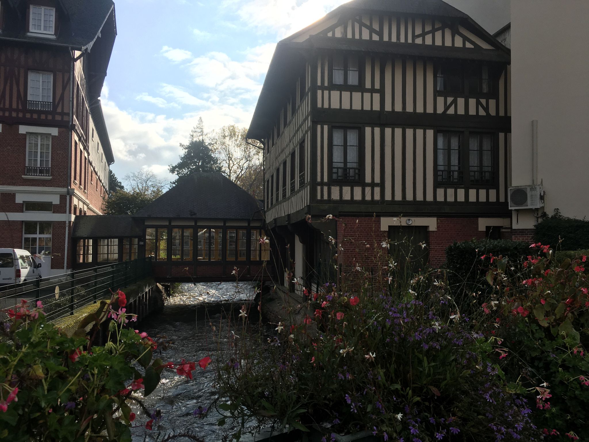 Photo of Flowers, river and normandy house, Lisieux, France.