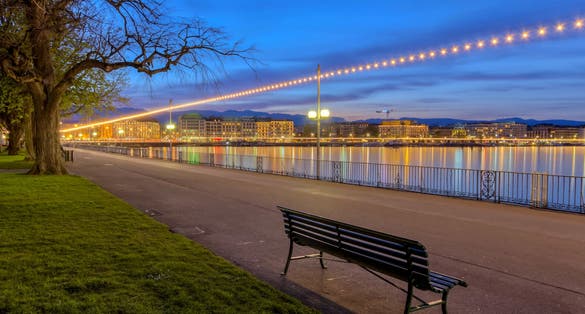 Photo of bench at the English garden promenade near the lake by night, Geneva, Switzerland.