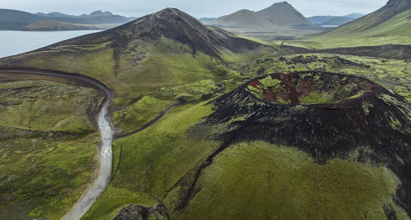 photo of Grábrókarhraun, a rough lava–field about 3,000 years old, covered with moss and birch bushes. The lava came from three craters, Grábrók, which is the largest, Grá­brókarfell, and a small crater that .