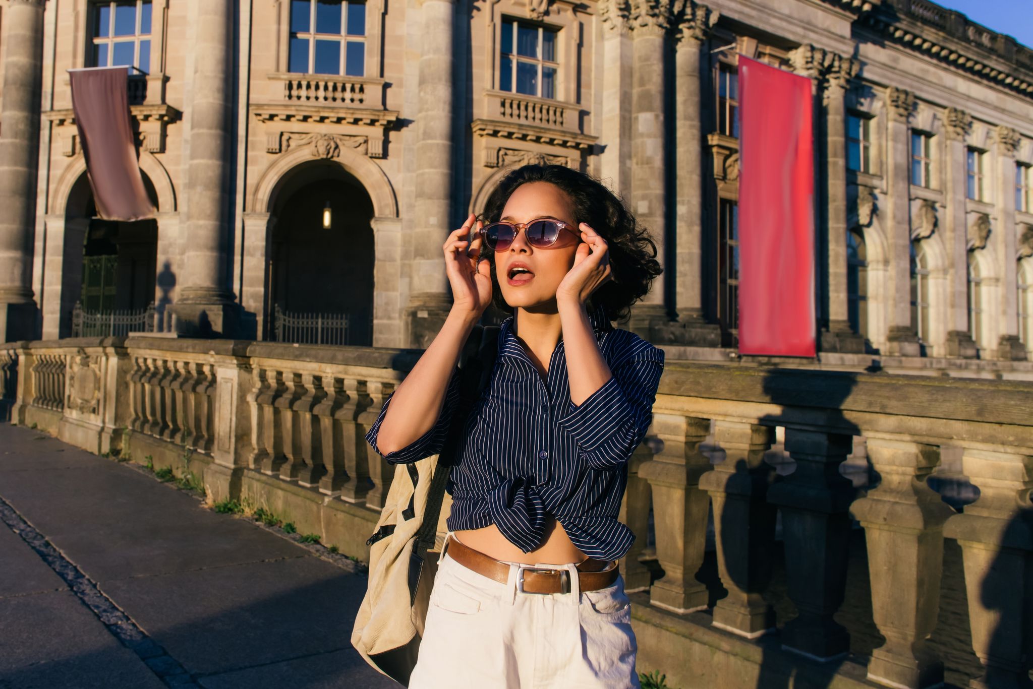 stylish young woman wearing sunglasses near bode museum in berlin