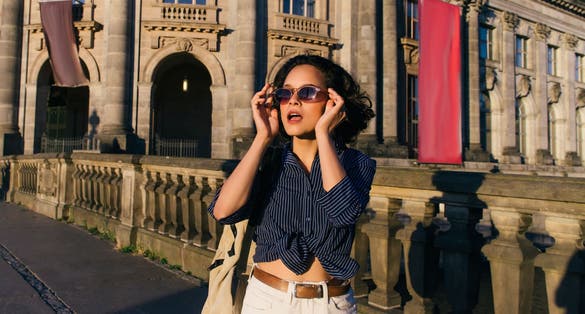 stylish young woman wearing sunglasses near bode museum in berlin