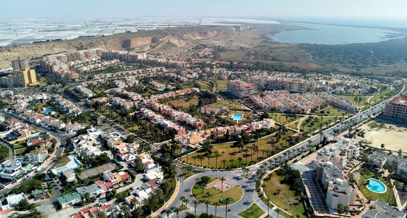 Aerial wide drone point of view photography Almerimar townscape with residential houses streets and roads, lot of greenhouses Victoria lake. El Ejido municipality in Almeria province. Andalucia, Spain