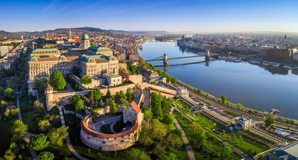 Photo of aerial panoramic skyline view of Buda Castle Royal Palace with Szechenyi Chain Bridge, St.Stephen's Basilica, Hungarian Parliament and Matthias Church at sunrise with blue sky, Budapest, Hungary.