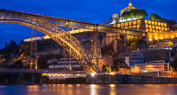 Photo of Dom Luis I bridge over Douro river and monastery of Serra do Pilar illuminated at night. Porto, Portugal.