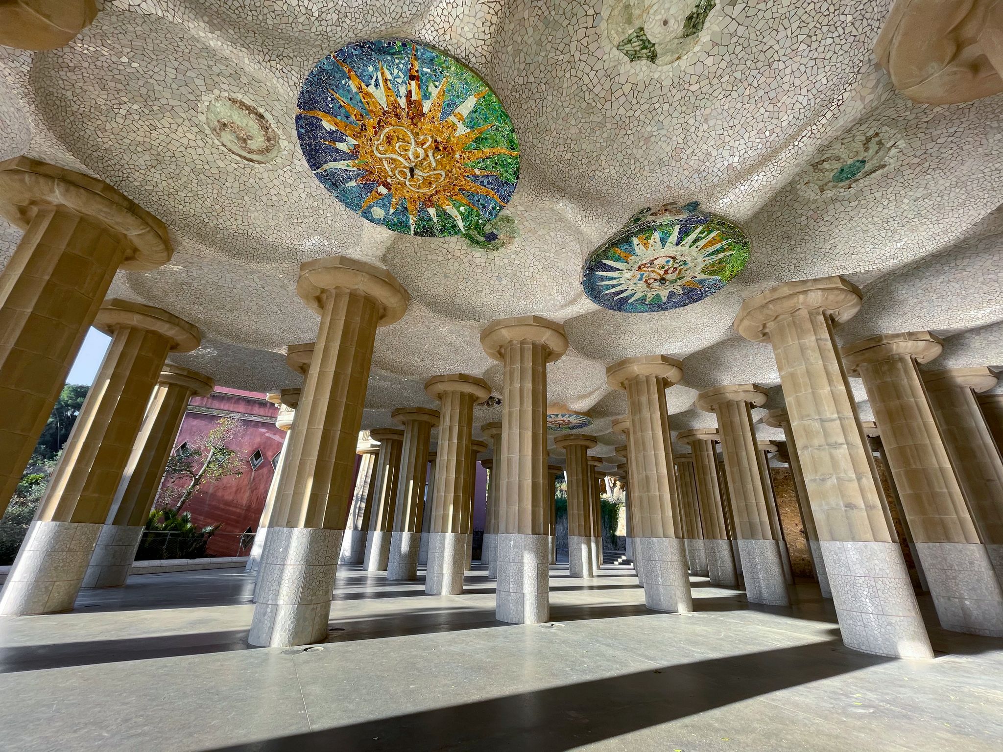 Photo of under the stunning Park Guell in Barcelona with colorful mosaic and columns, Catalonia, Spain.