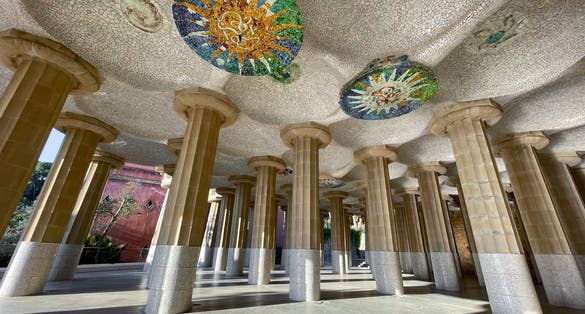 Photo of under the stunning Park Guell in Barcelona with colorful mosaic and columns, Catalonia, Spain.