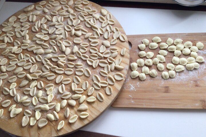 Hands in dough between orecchiette and focaccia in nature