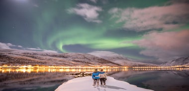 Photo of houses, bridge and panorama of Norwegian city Tromso beyond the Arctic circle from mountain in Norwegian fjords.
