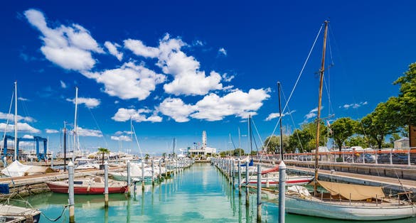 Photo of Scenic spring view of pier with ancient and modern buildings, ships, yachts and other boats in Rimini, Italy.