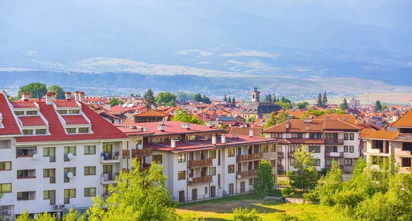 Photo of Bansko, Bulgaria summer town panorama of bulgarian ski resort with Rila mountain peaks and church tower.