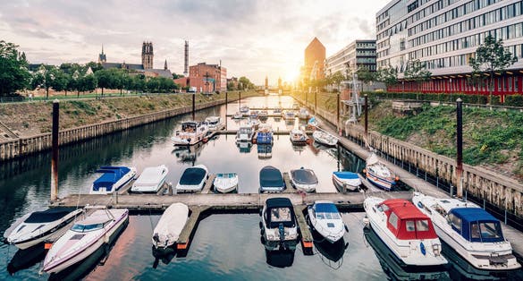Photo of Duisburg Marina with ships and modern buildings, Germany.