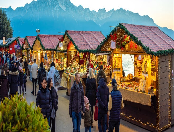 Montreux Noel Christmas Market with festive stalls, shoppers, and mountain views at sunset..jpg