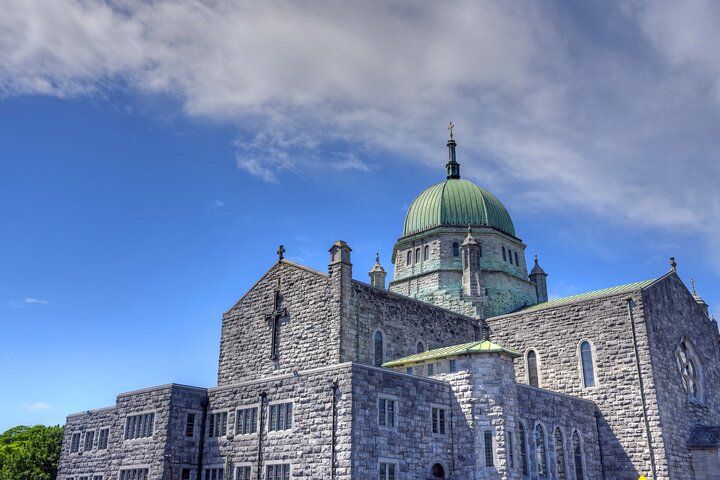 A view of Galway Cathedral in Ireland, with its grey stone walls, green dome, and a bright blue sky above..jpg