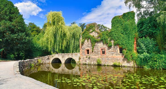 photo of view of Old ruin called 'Kirchenruine zum heiligen Grab' in front of pond in public park called 'Schöntal' in center of German city Aschaffenburg