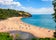 Photo of aerial view of sunny seascape with people enjoying the beach in Blackpool Sands, Devon, UK.