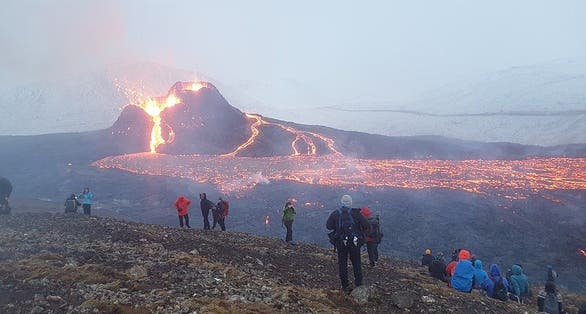 photo of view People on the slopes of Fagradalsfjall, watching the Geldingadalir eruption, Iceland.