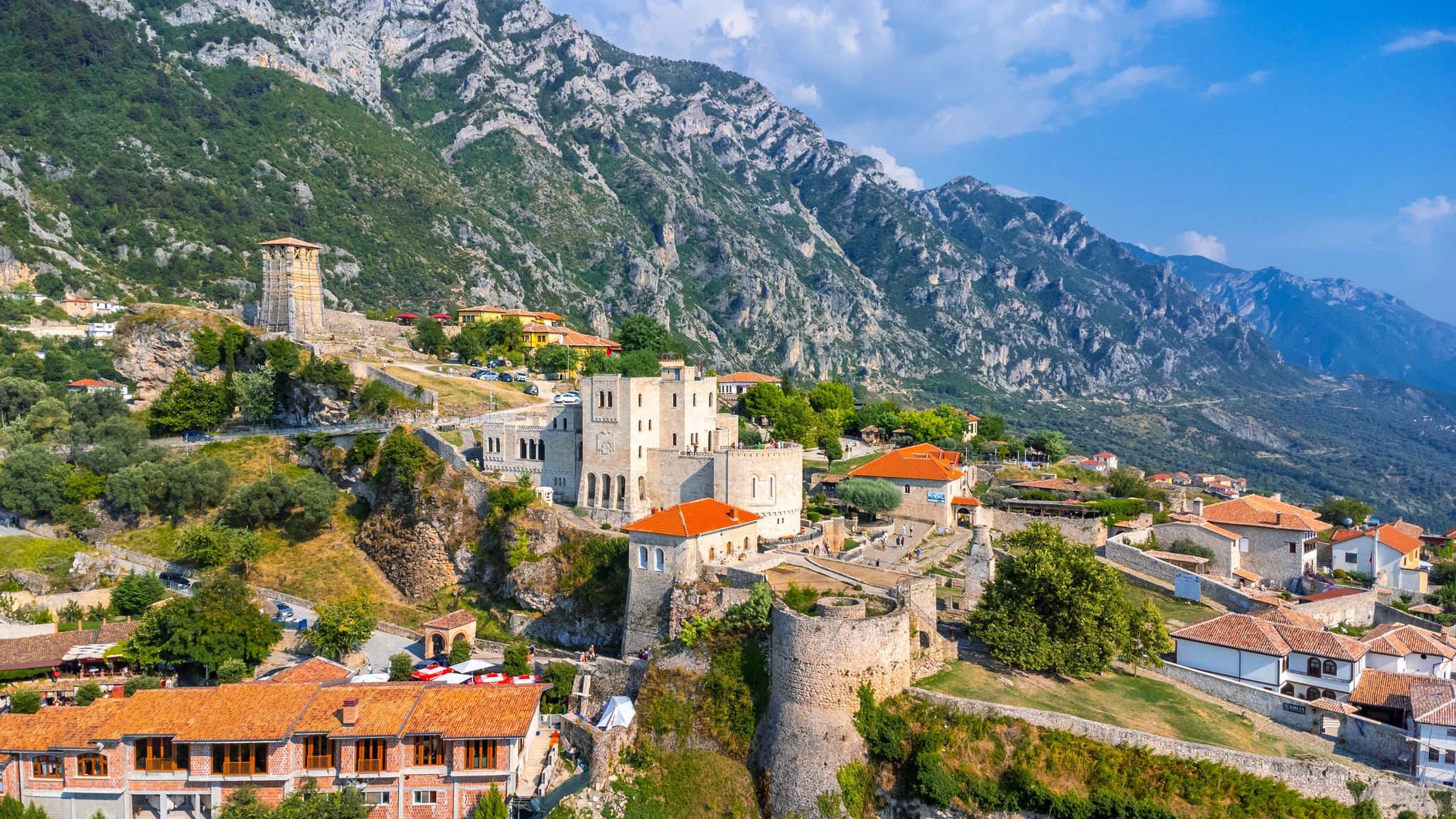 Photo of aerial drone view of Kruje Castle and its fortress, inside the Kruje tower and museum with the mountains in the background, Albania.