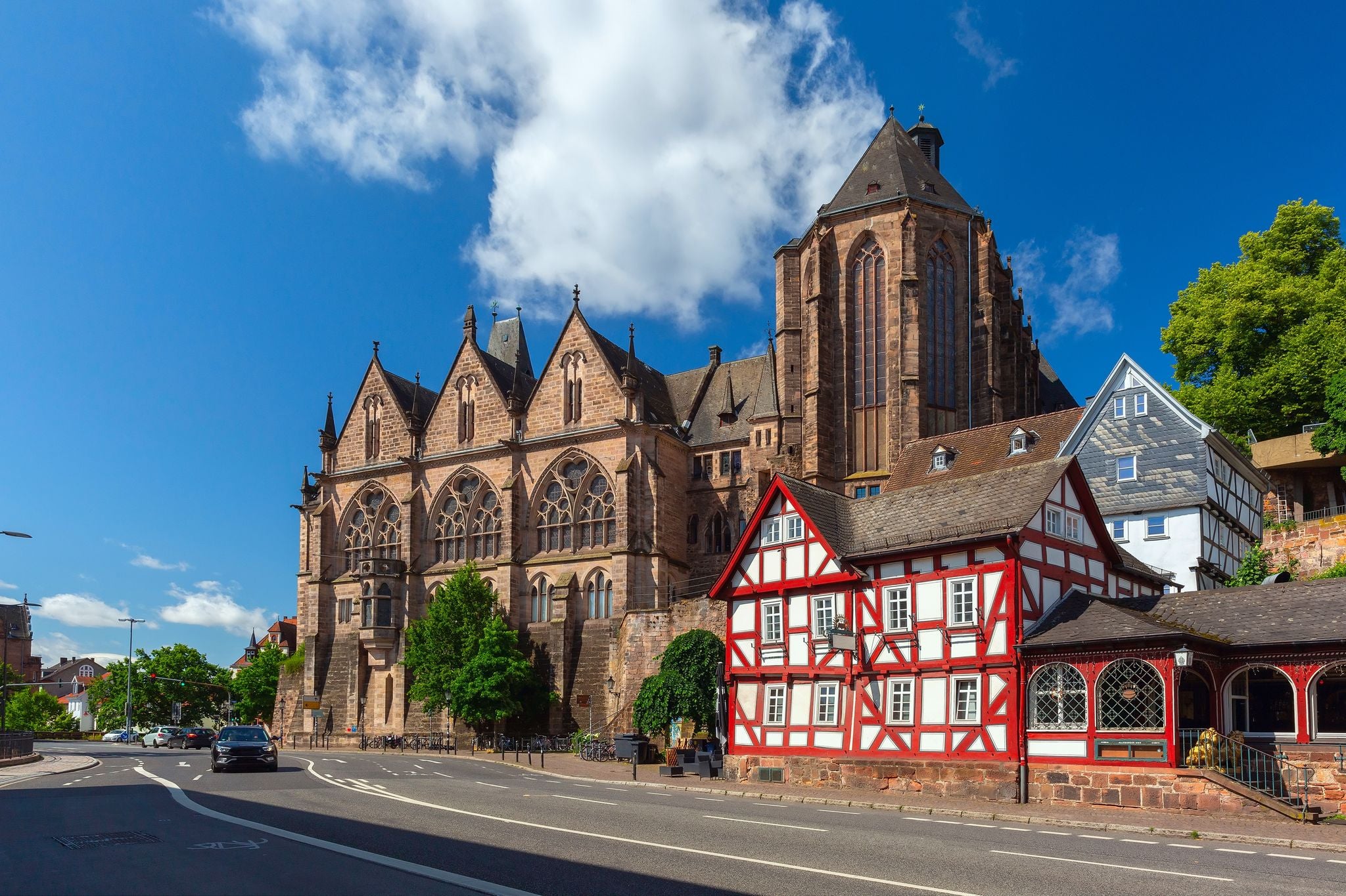 Photo of Medieval street with traditional half-timbered houses and University Church, Marburg an der Lahn, Hesse, Germany.