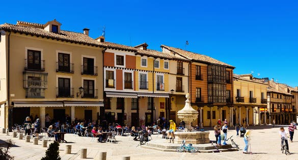 Photo of Streets of El Burgo de Osma, province of Soria, Spain. View of people sitting at tables in outdoor cafe near fountain.