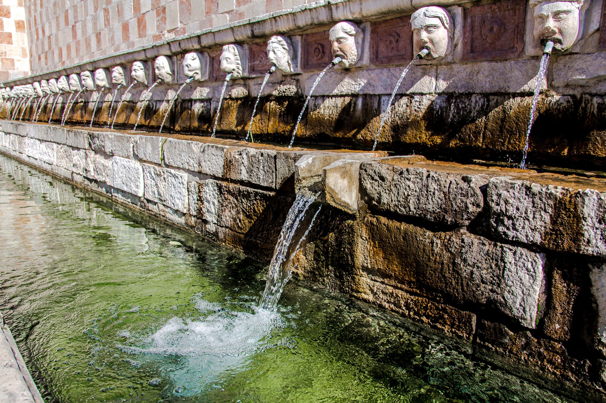 Fountain of the 99 Spouts (Fontana delle 99 cannelle), Historic fountain with 99 jets distribuited along three walls, L Aquila, Italy.