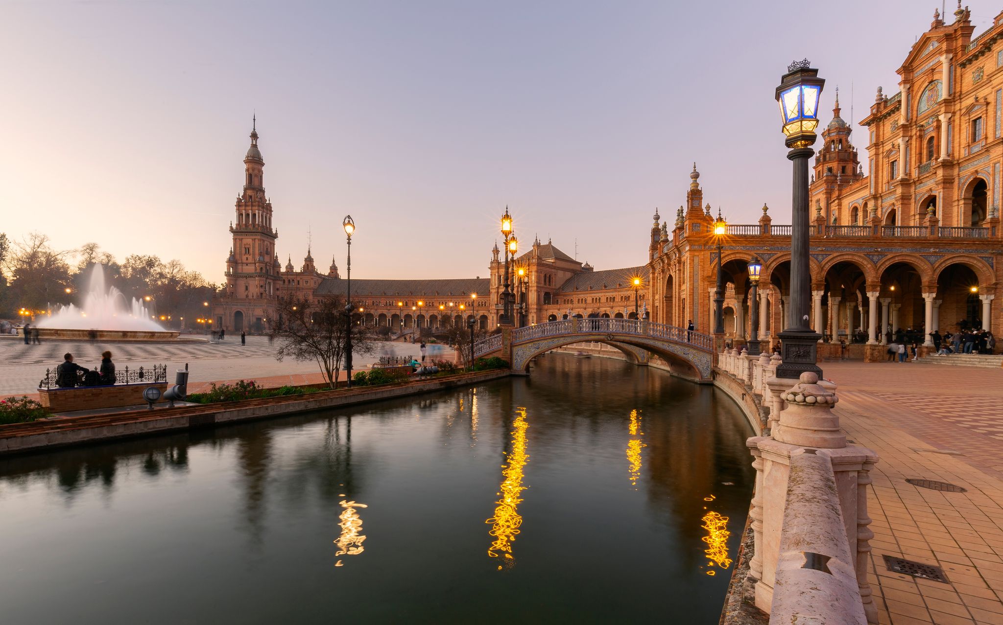Photo of scenic view of Plaza de EspaÃ±a The Plaza de EspaÃ±a is a plaza in the Parque de MarÃ­a Luisa, Historical landmark in Seville sunset, Spain .
