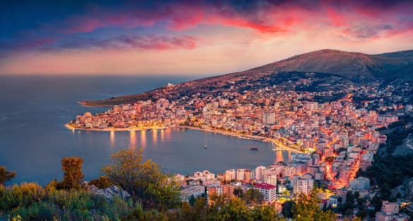photo of aerial morning cityscape of Saranda port. Majestic sunrise on Ionian sea. Fantastic outdoor scene of Albania, view from Lekursi Castle. Traveling concept background.
