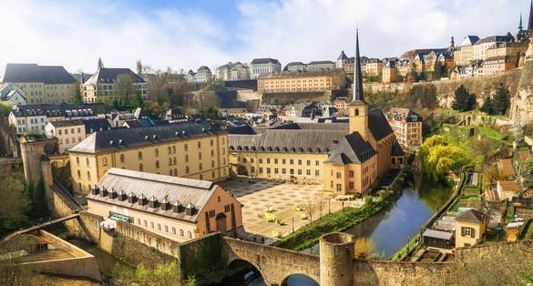photo of panoramic view of Luxembourg city from observation deck above the bock casemates. Neumünster abbey, stone bridge above alzette river, colorful living houses, catholic churches.