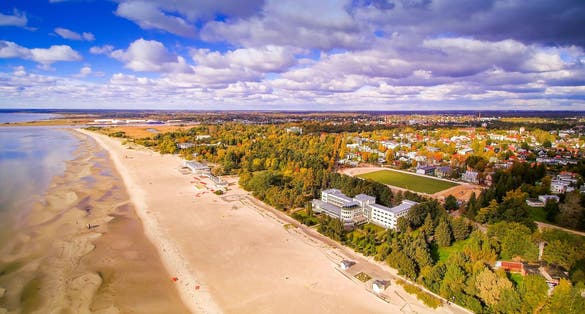 Photo of aerial view of the beautiful seaside city of Parnu, Estonia. Seen also the clouds from the sky and the coastal beach in the side