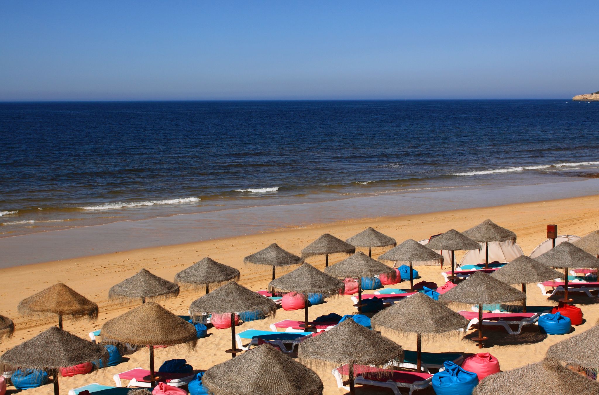 Portugal, Algarve Region, Silves, ArmaÃ?Â§ao de Pera beach with straw sunshades and a crystal clear Atlantic Ocean