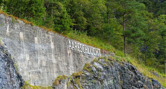 photo of lettering Aare Gorge at entrance of Landmark on a cloudy late summer day in Meiringen, Switzerland.
