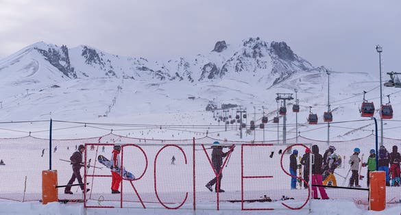 photo of panoramic view of Erciyes Ski Resort with people skiing on the ski slope in Kayseri, Turkey.