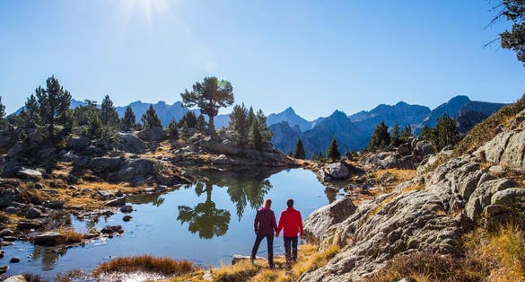 Photo of Young hiker couple in autumn in Aiguestortes and Sant Maurici National Park, Pyrenees, Spain.