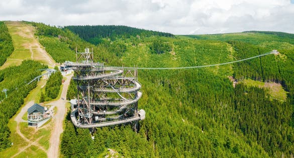 Photo of aerial view of the worlds longest 721 meter suspension footbridge Sky bridge and observation tower the Sky walk in the forest, between mountains, Dolni Morava Ski Resort, Czech Republic.