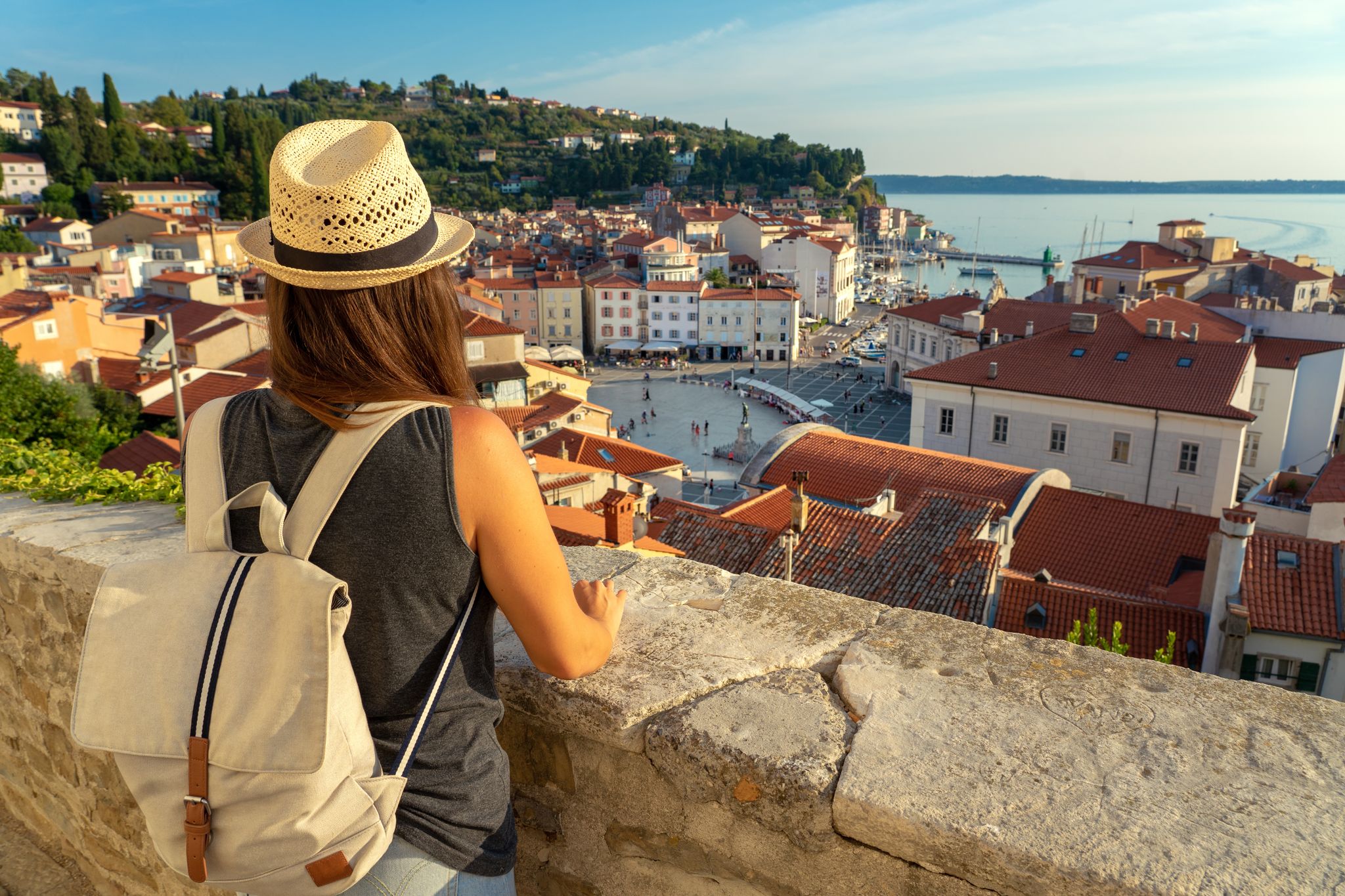 Tourist woman with backpack watching Piran and the Tartini square