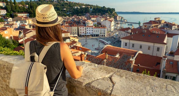 Tourist woman with backpack watching Piran and the Tartini square