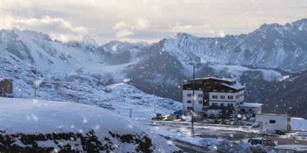 photo of snowflakes and beautiful view of accommodation on Passo dello Stelvio, Bormio, Italy.